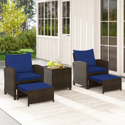 Beige 5-piece patio rattan furniture set with 2 ottomans and tempered glass coffee table for outdoor patio seating.
