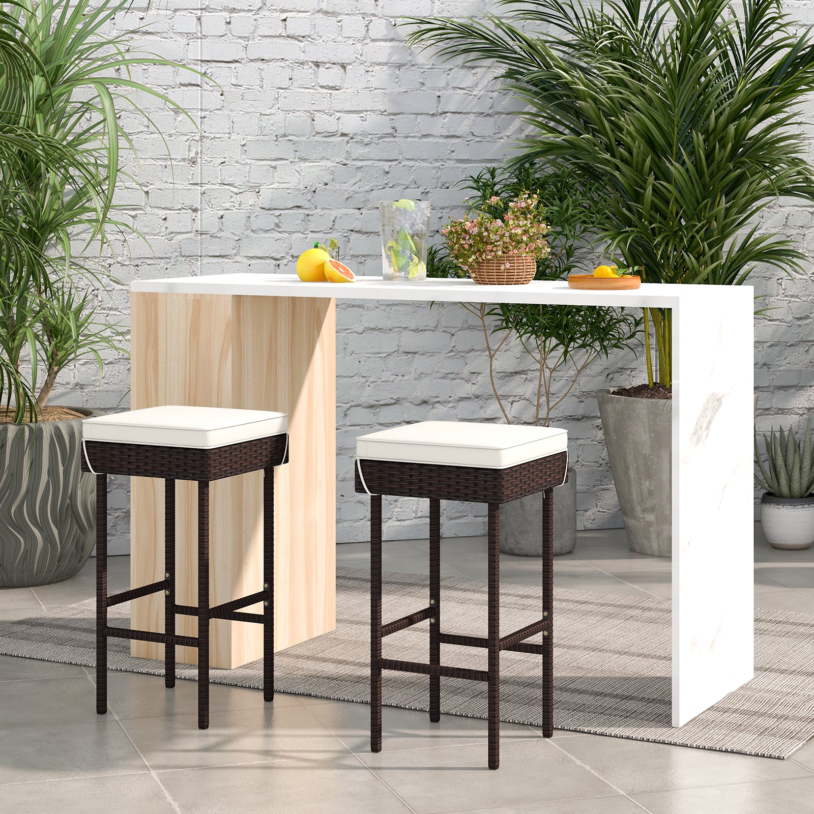 Set of two rattan outdoor patio barstools with footrests and soft cushions, ideal for backyard or balcony seating.