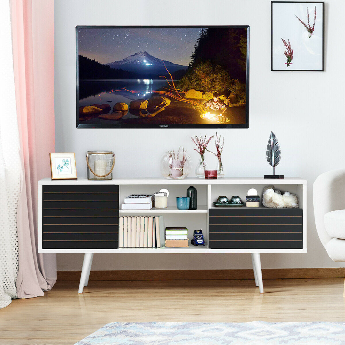 Mid-century modern TV stand with storage shelves for 65-inch TVs, made by Direct by Wilsons Home Store, in a living room setting.