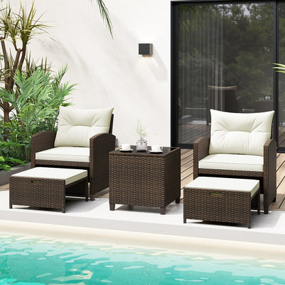 Beige 5-piece patio rattan furniture set with 2 ottomans and tempered glass coffee table for outdoor patio relaxation.