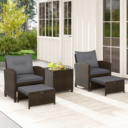 Five-piece beige patio rattan furniture set with two ottomans and a tempered glass coffee table for outdoor patio lounging.