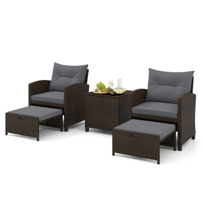 Five-piece beige patio rattan furniture set with two ottomans and a tempered glass coffee table for outdoor patio lounging.