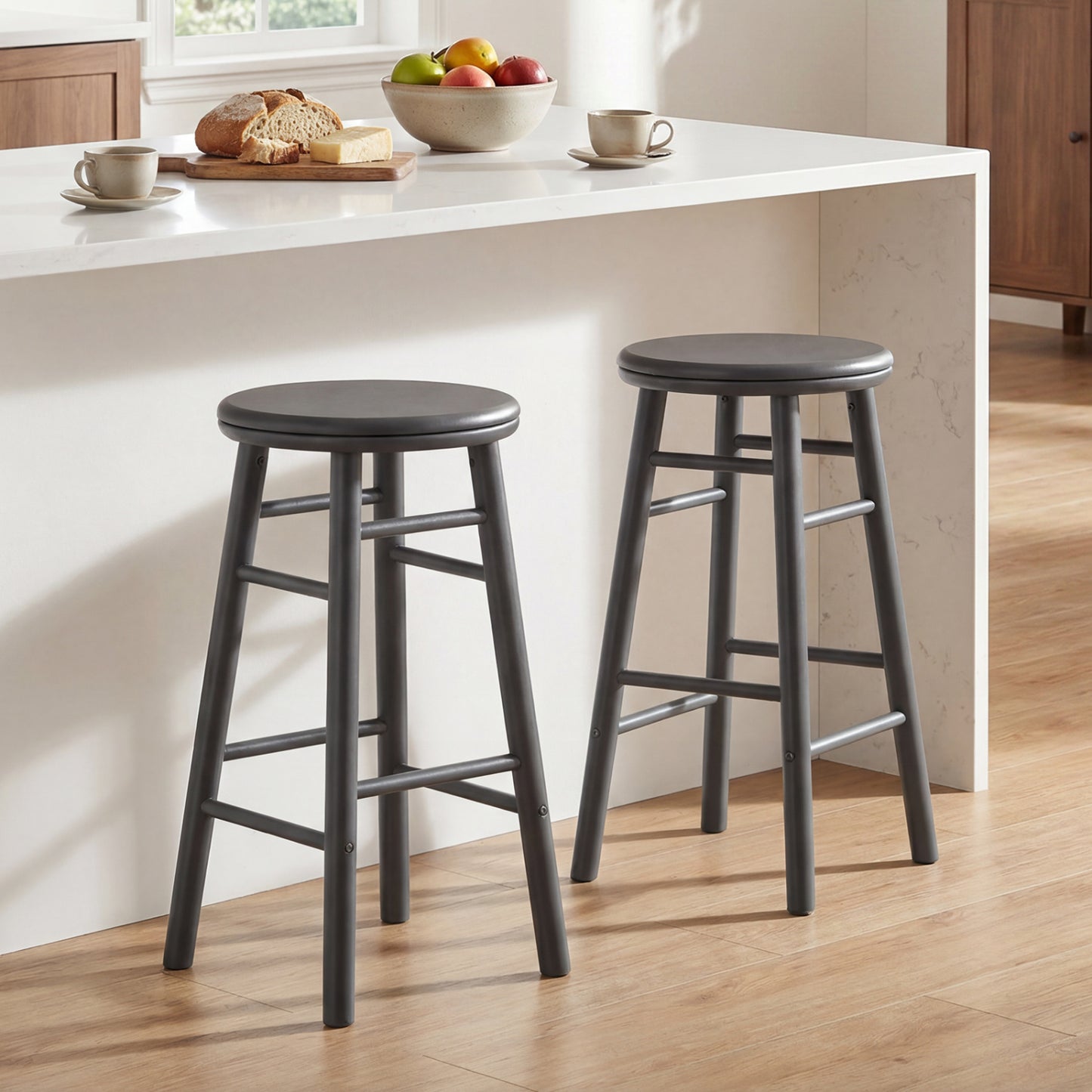 Set of two 24-inch gray swivel bar stools with footrests and crossbars, featuring modern kitchen and dining furniture design.