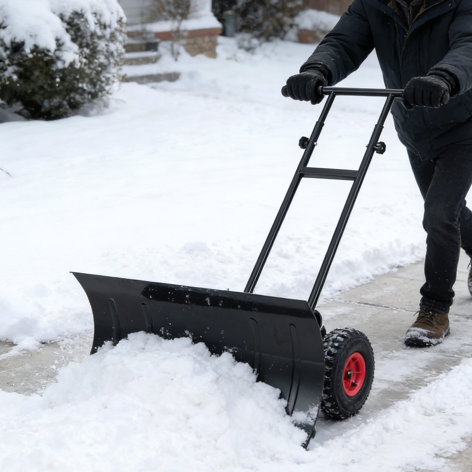 Heavy-duty 29-inch snow pusher with wheels, adjustable handle, and black metal blade for outdoor snow removal.