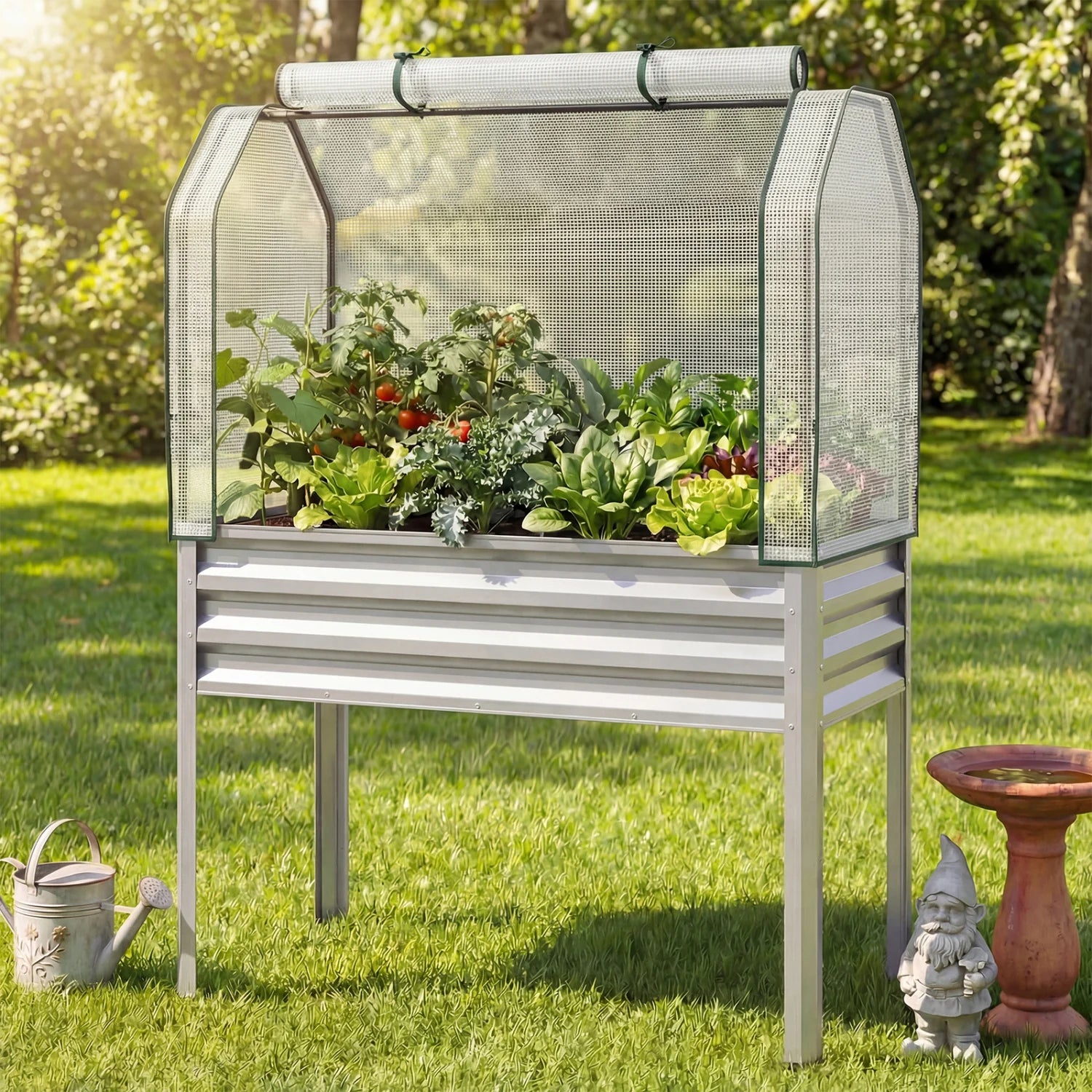 Two galvanized raised garden beds with legs and green greenhouse covers for vegetables and flowers in an outdoor garden setting.