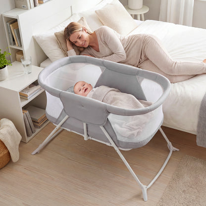 Beige 2-in-1 baby bassinet with rocking motion and breathable mesh, foldable bedside sleeper designed for nursery comfort.