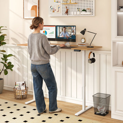 Height adjustable 63x24 inch Wilsons Home Store sit-stand computer desk with 3 memory presets in natural wood finish.