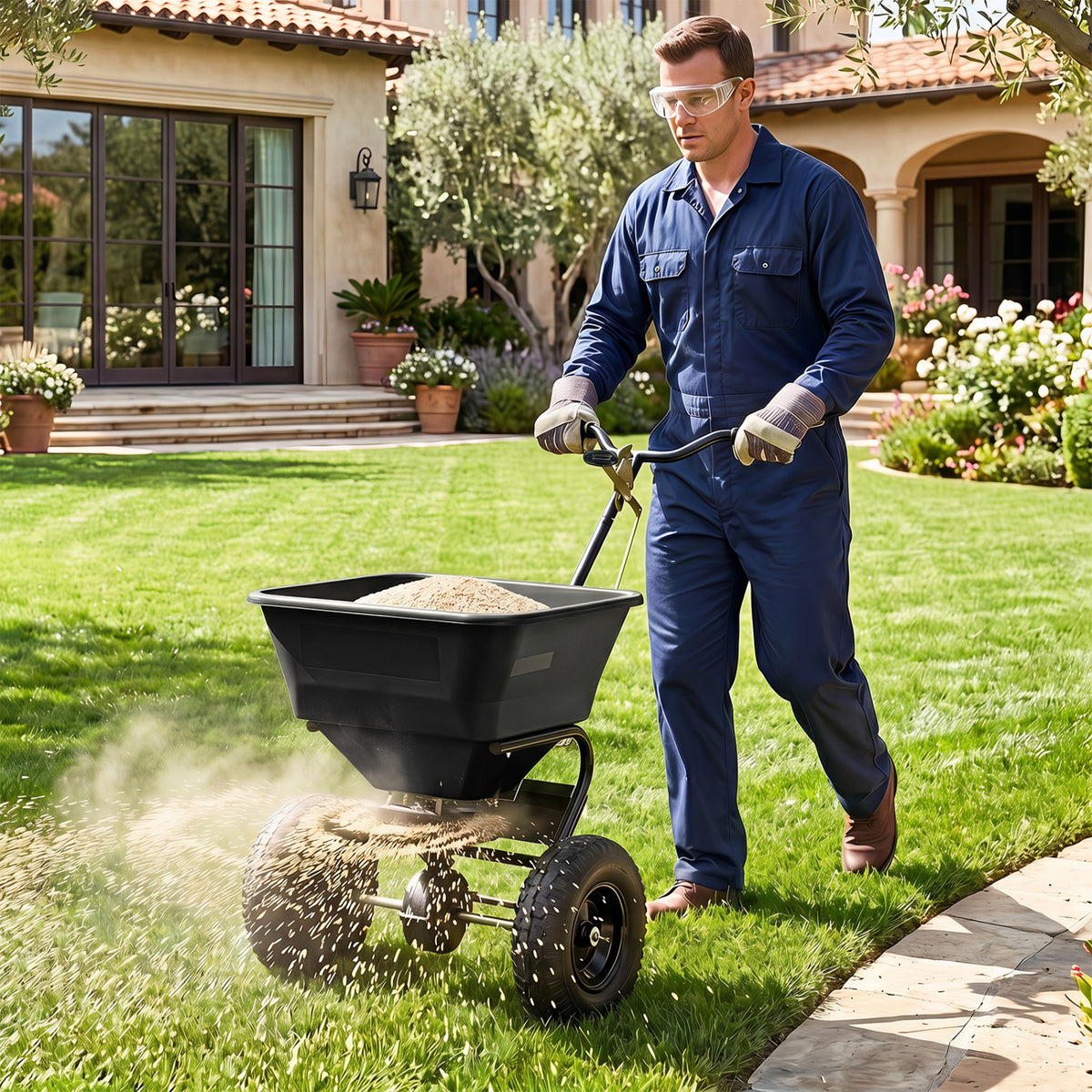 Black 66 lbs walk-behind broadcast spreader with 13-inch all-terrain tires for lawn care from Wilsons Home Store.