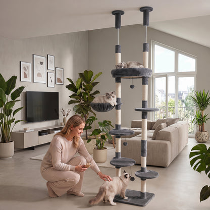 Beige 6-tier floor-to-ceiling cat tree with plush beds and sisal scratching posts, designed for cats to climb and relax.