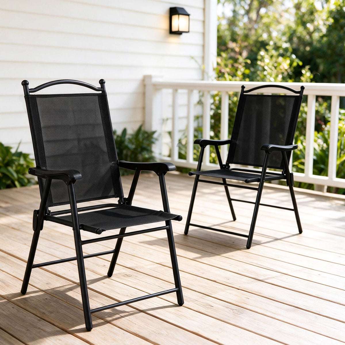Set of four black folding patio chairs with armrests and high backs for outdoor lawn and deck seating.