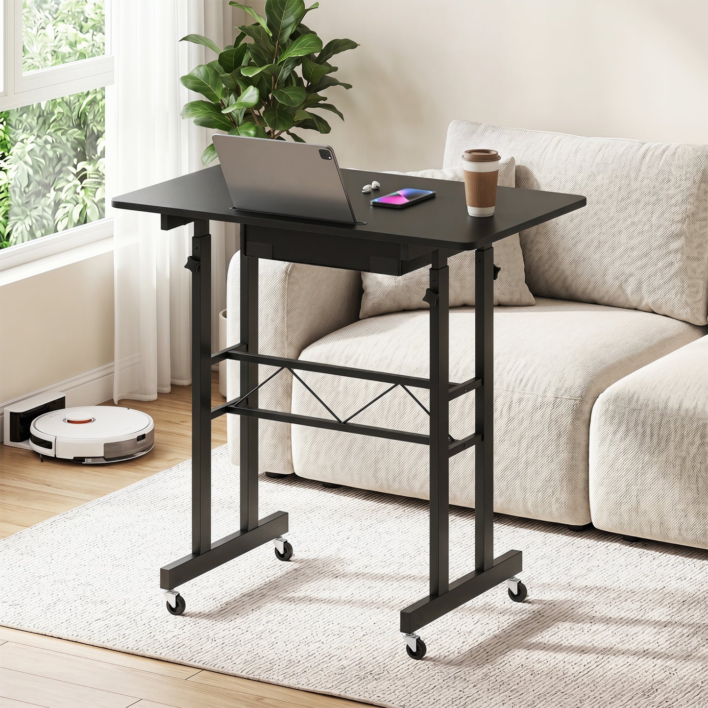 Black height adjustable laptop desk with fabric drawer, tablet holder, and lockable wheels for flexible home office setup.