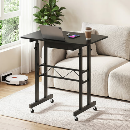 Black height adjustable laptop desk with fabric drawer, tablet holder, and lockable wheels for flexible home office setup.