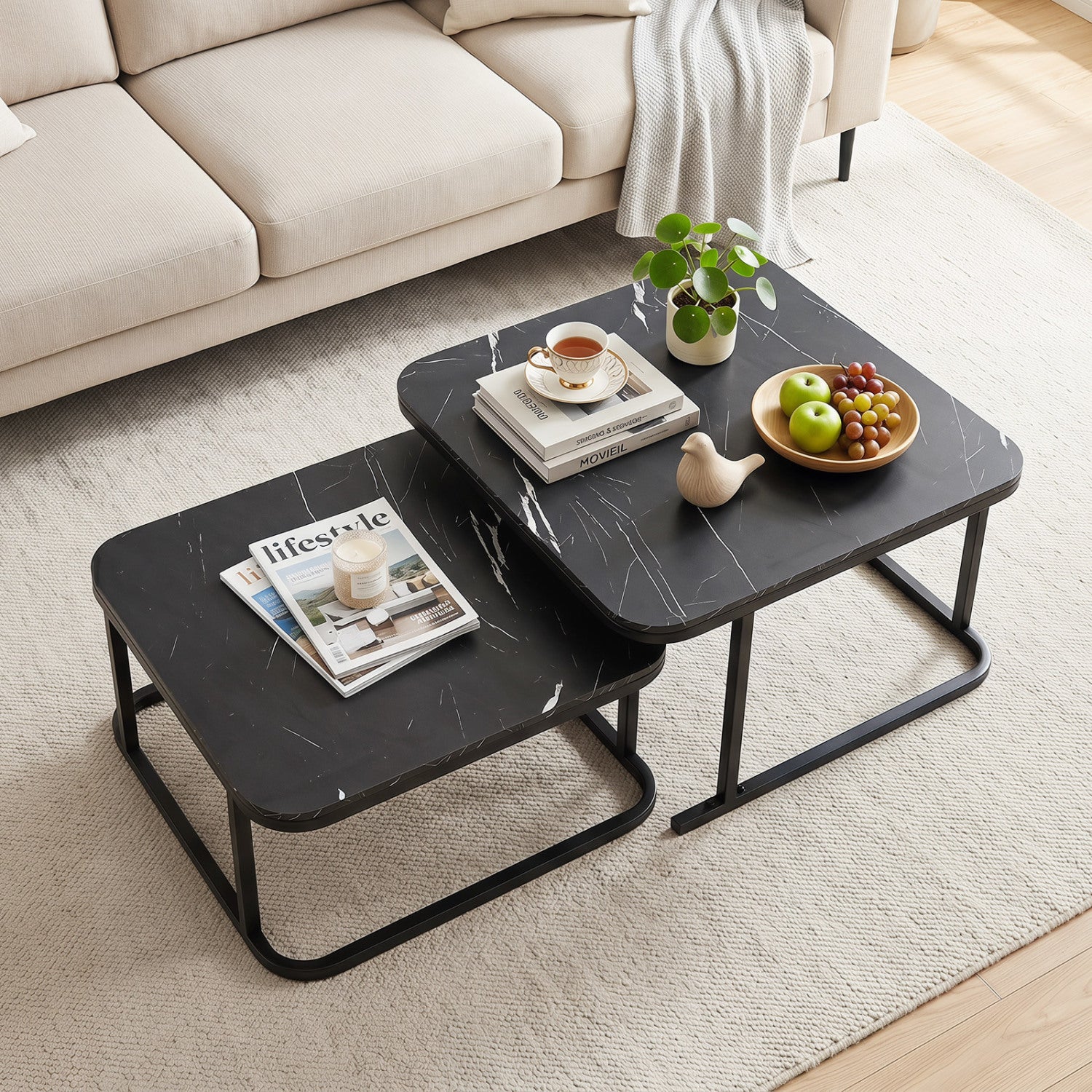 Set of two nesting coffee tables with faux marble tops and black metal frames, ideal for living room decor.