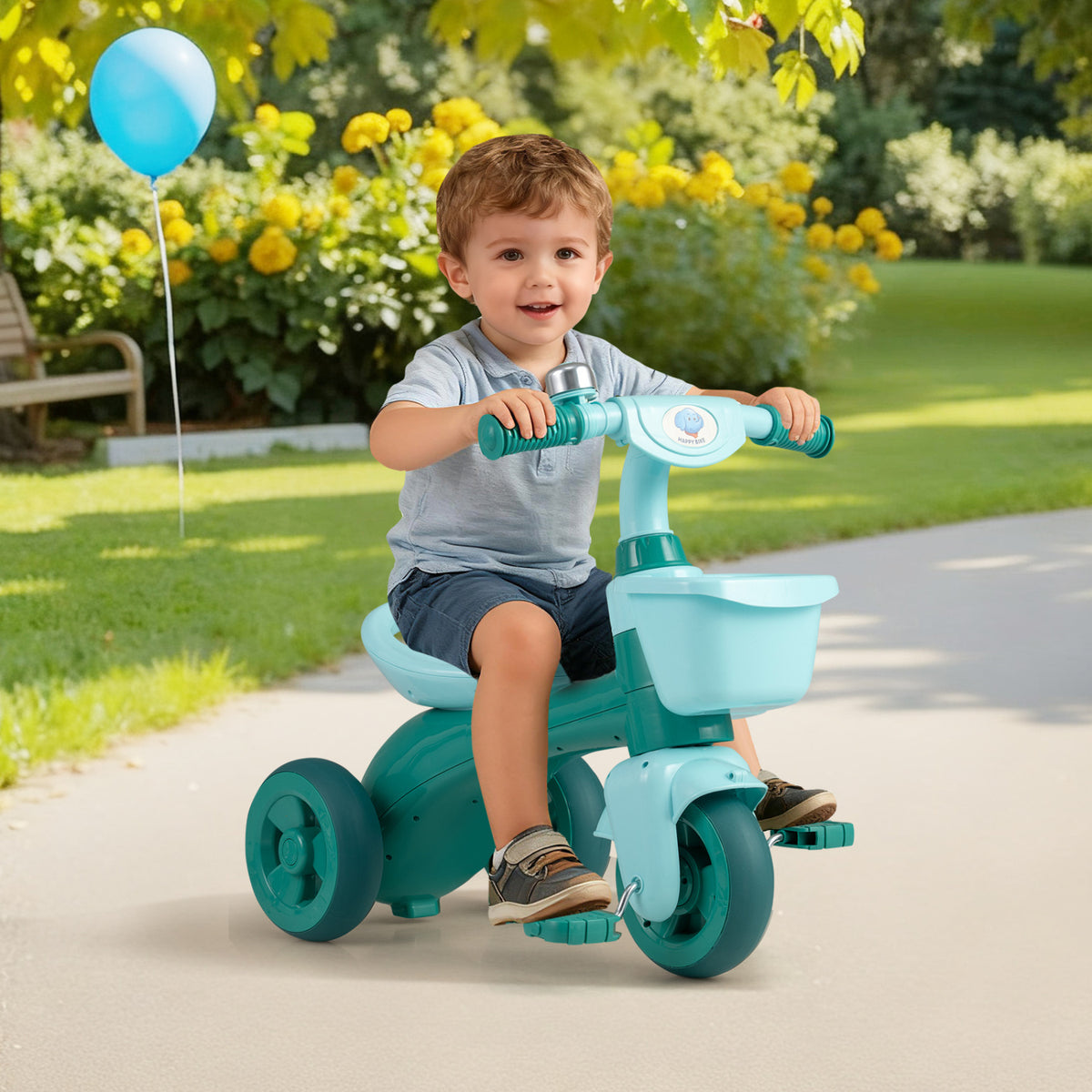 Green toddler tricycle with limited steering, front baskets, and bell, designed for push and pedal riding for young children.