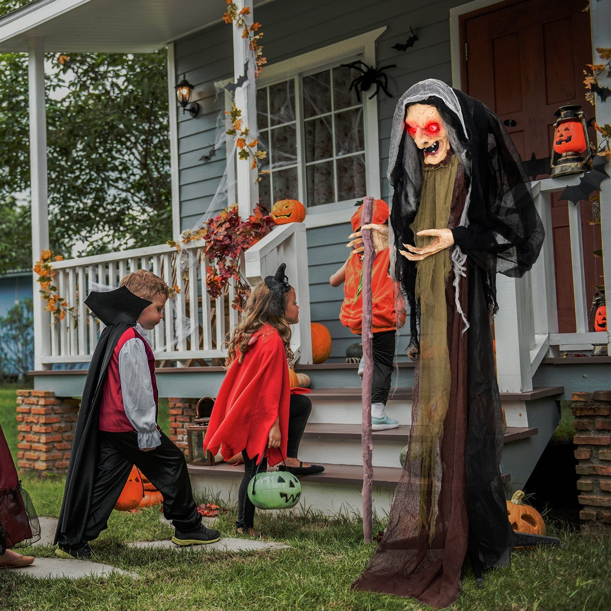 Life size animatronic witch with glowing eyes and broomstick, featuring pre-recorded Halloween phrases for spooky holiday decor.